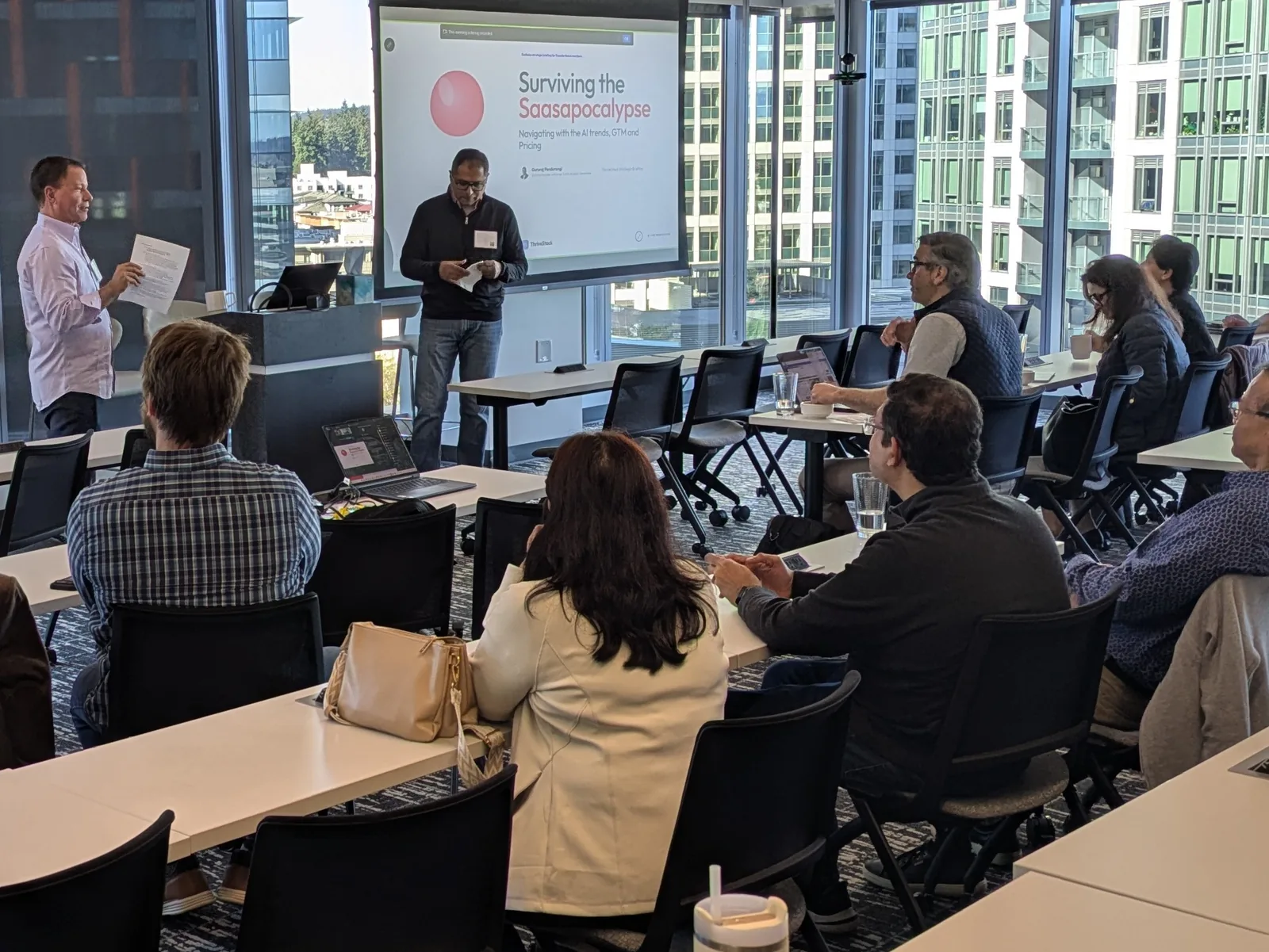 Two speakers leading a FounderNexus workshop with participants seated around tables
